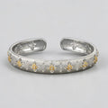 Bracelet jonc Jewelry by Kitana en argent 925 texturé avec motifs floraux dorés contrastants et finition brossée