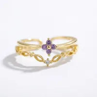 Bague dorée réglable, dentelle filigranée à deux rangs et pierre violette au centre.