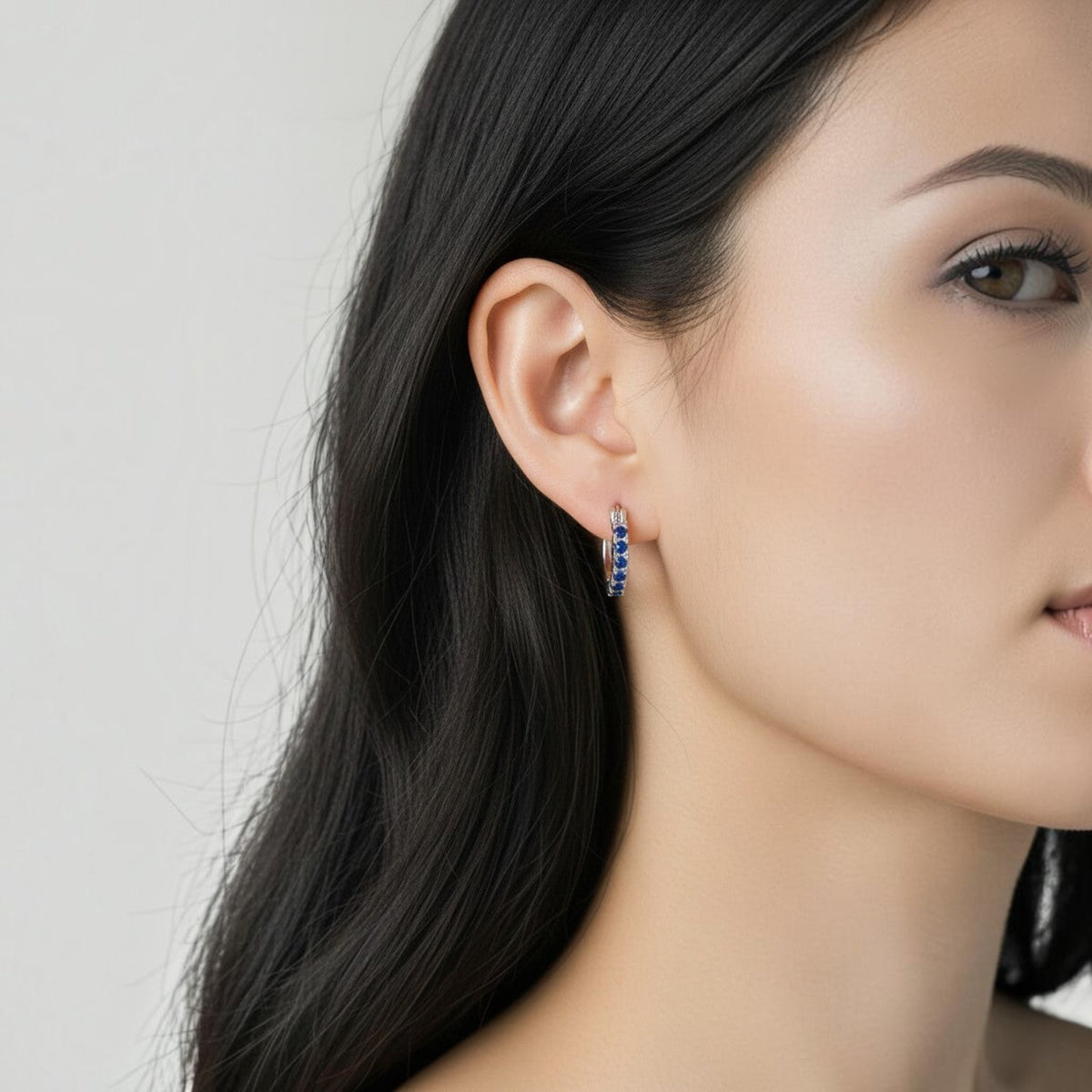 Créoles Jewelry by Kitana en argent sterling 925 pavées d'oxydes de zirconium bleu saphir portées à l'oreille