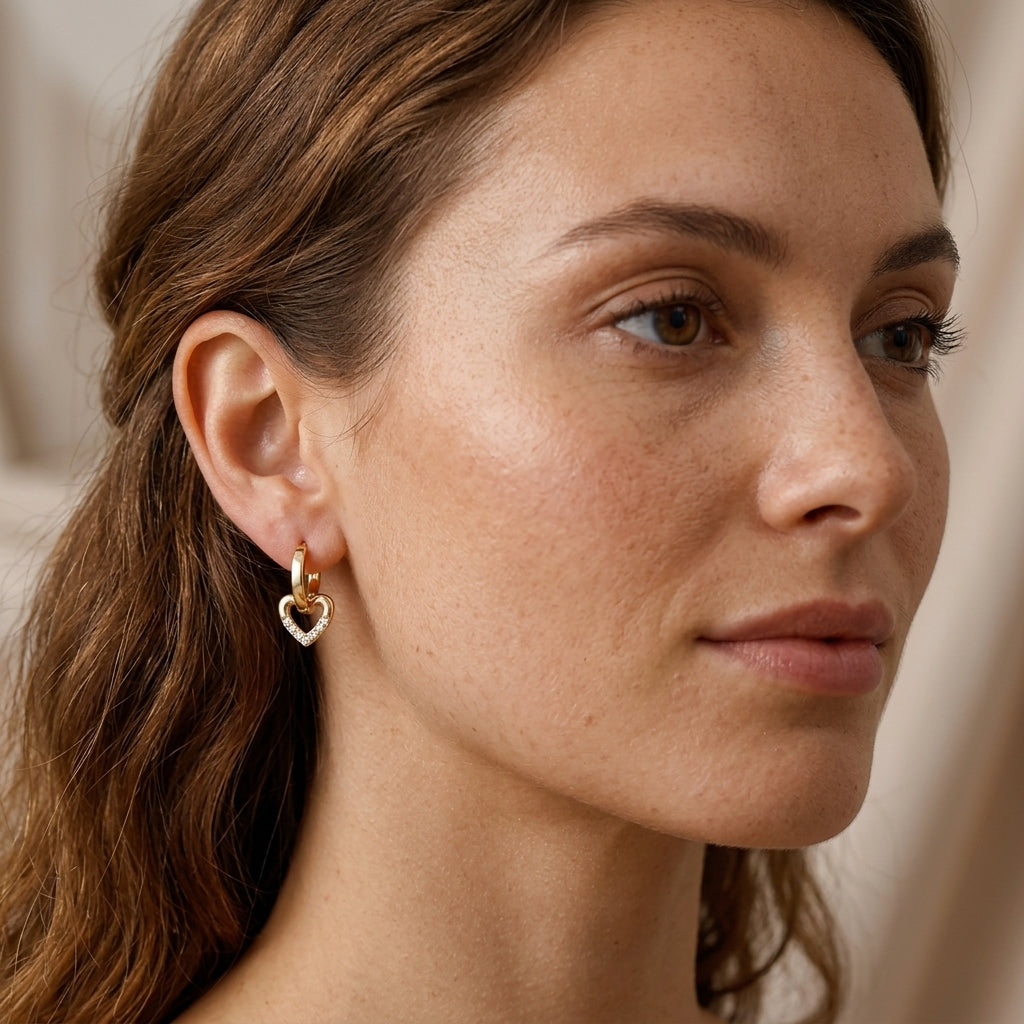 Femme portant des créoles dorées pendantes cœur zircons plaqué or 18k — Jewelry by Kitana