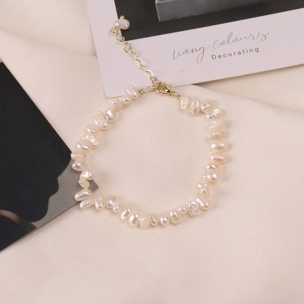 Bracelet en perles d’eau douce blanches, chaîne dorée et fermoir visible