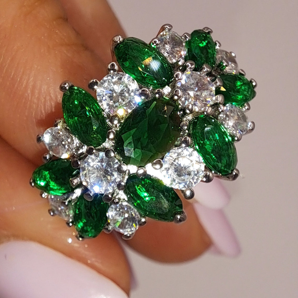 jewelry by kitana Gros plan réel de la bague argentée ornée de zircons verts et blancs en bouquet
