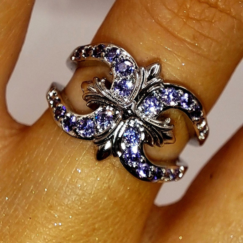 Bague argentée portée avec motif tourbillonnant et zircons violets scintillants
jewelry by kitana