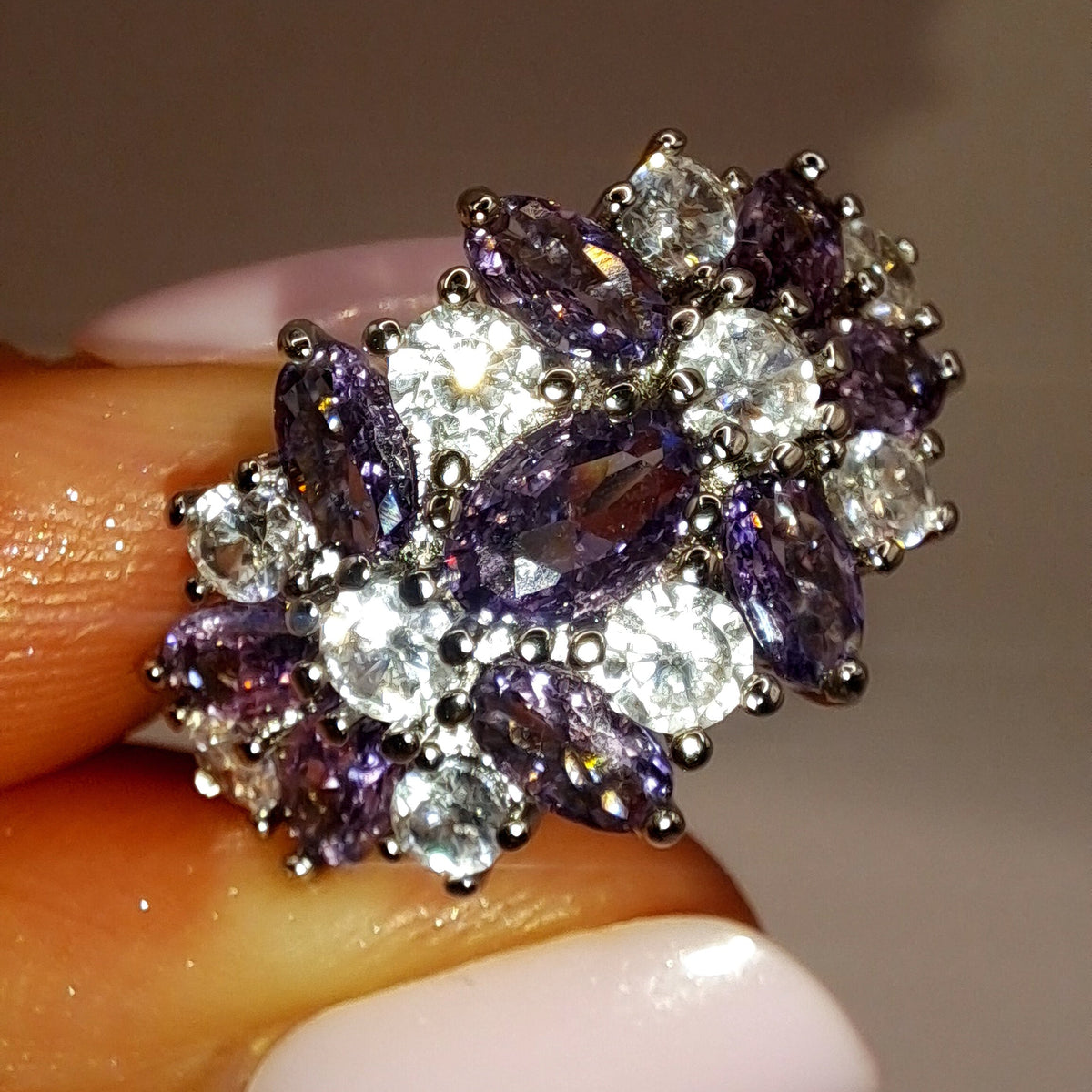 Gros plan réel de la bague argentée ornée de zircons violets et blancs en bouquet
jewelry by kitana 