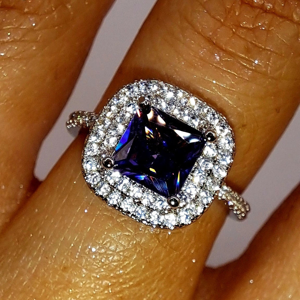 Bague argentée portée avec zircon violet carré et double halo de zircons blancs
jewelry by kitana 