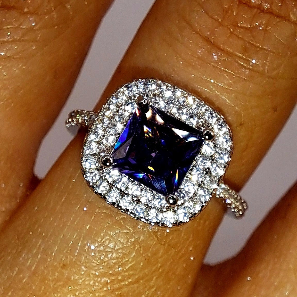 Bague argentée portée avec zircon violet carré et double halo de zircons blancs
jewelry by kitana 