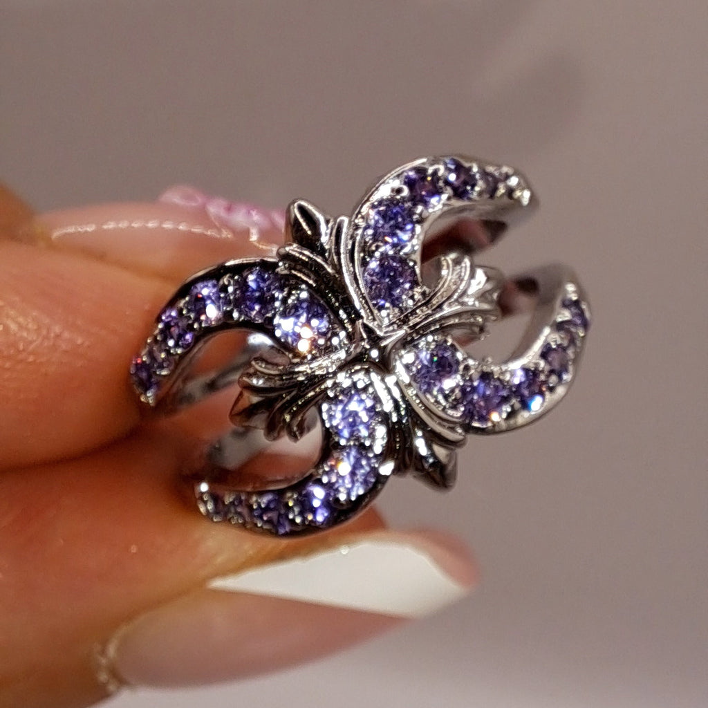 Gros plan réel de la bague ajustable argentée ornée de zircons violets
jewelry by kitana 