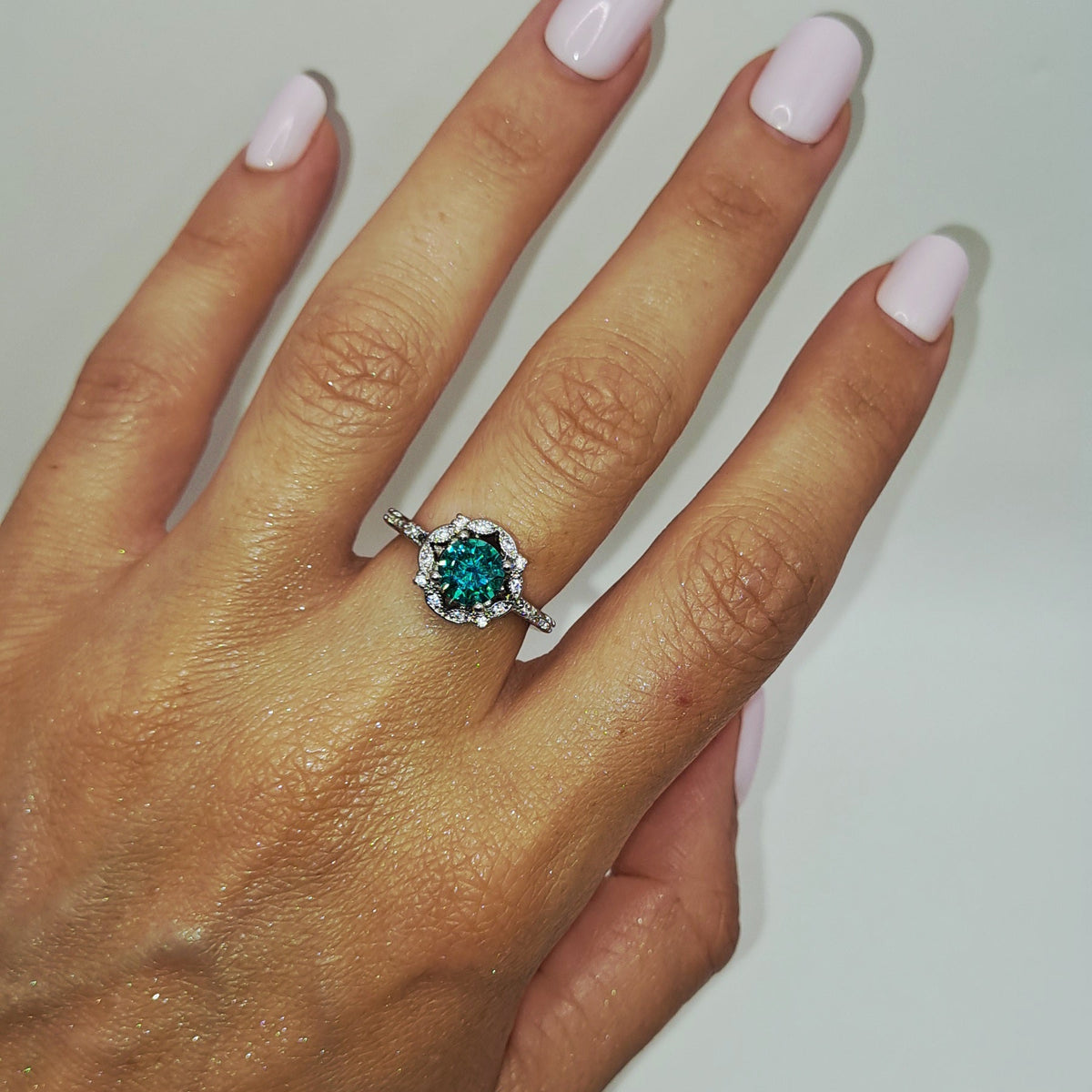Bague solitaire vert d’eau portée sur la main pour montrer sa taille réelle
